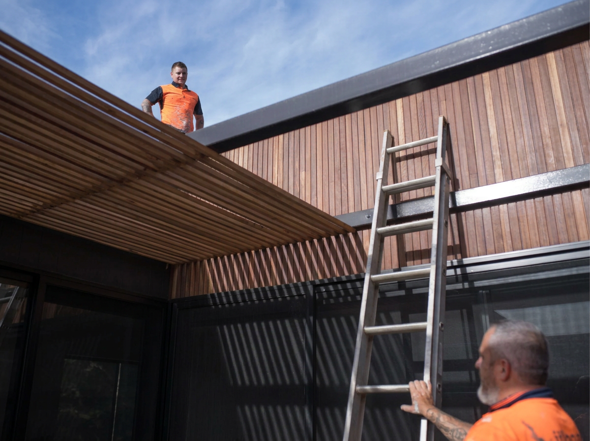Two Gaboras Construction workers in orange shirts at a commercial building site